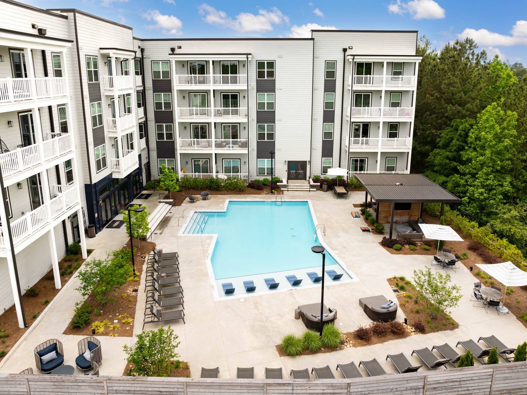 an overhead view of an apartment building with a swimming pool